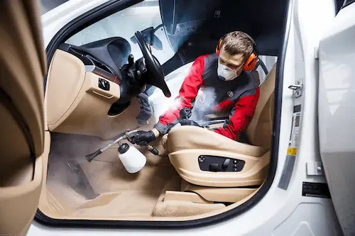 Echipa curatand si protejand interiorul unui autoturism